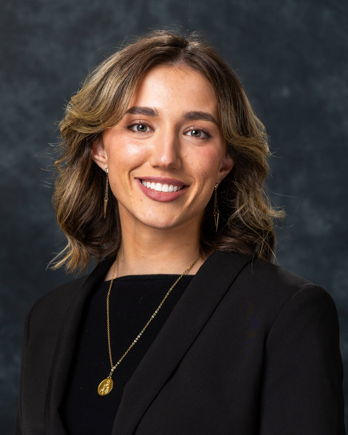 Student wearing a black blazer posing for a studio headshot